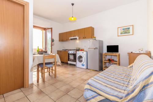 una camera con cucina completa di tavolo e frigorifero di Daniela Apartments a Massa
