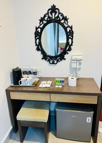 a desk with a mirror on a wall at Elite Hotel KL Sentral in Kuala Lumpur