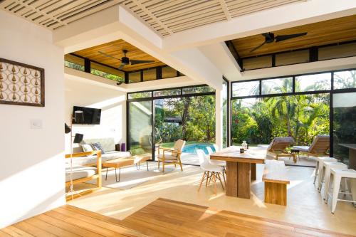 an open living room with a table and chairs at Nalu Nosara Pool Villa Sol in Playa Guiones