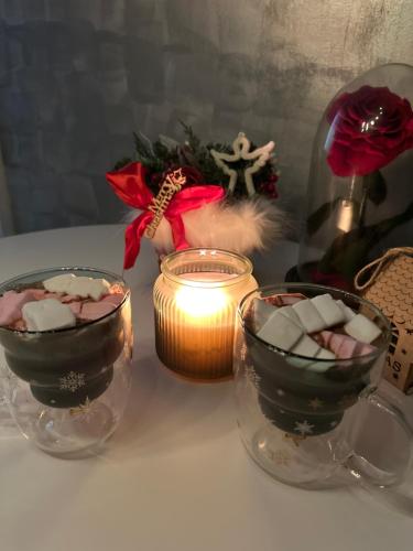 a table with two glass bowls and a candle at Romantic studio AxS in Floreşti