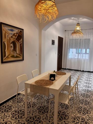 Un comedor con una mesa y sillas blancas. en Casa Norte, en Tetuán