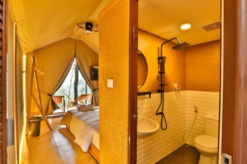a tent bedroom with a bed and a bathroom at The Full Hot Spring & Resort in Kemloko-gede
