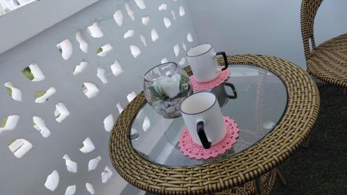 Una mesa de cristal con dos jarrones encima. en Arishi cozy haven, en Malindi