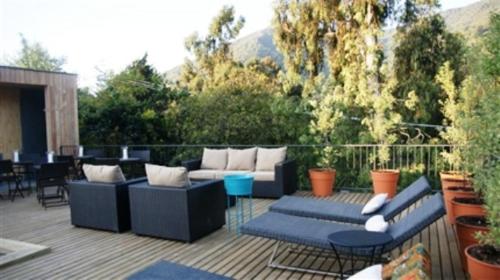 a patio with couches and tables on a deck at Hotel Casa Zapallar in Zapallar