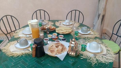 een groene tafel met eten en drinken erop bij Riad 29 Mouassine in Marrakesh