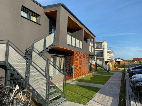 een gebouw met een trap naast een parkeerplaats bij Apartamenty Czerwone Korale in Chłopy