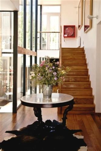 a room with a table with a vase of flowers on it at Hotel Casa Zapallar in Zapallar