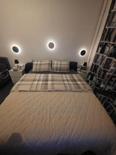 a bedroom with a large bed with a blanket at Chambre privée avec Clé in Beauvais