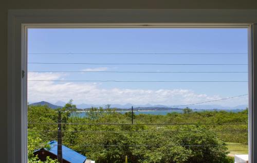 Apê Alegria - Capri Morada & Mar - Frente mar في ساو فرانسيسكو دو سول: نافذة مطلة على المياه والجبال