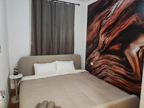 Apartments Sunny في بيشيشي: غرفة نوم بها سرير ولوحة على الحائط