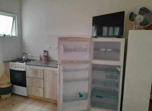 een keuken met een lege koelkast en een fornuis bij Viento Sur in Estancia El Polomo