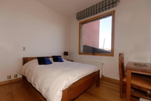 a bedroom with a large bed and a window at Casa Farellones in Farellones