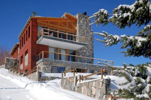 a log cabin in the snow with snow covered trees at Casa Farellones in Farellones