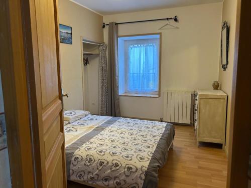 een kleine slaapkamer met een bed en een raam bij 2 Chambres dans maison typique in Beaumont-lès-Valence
