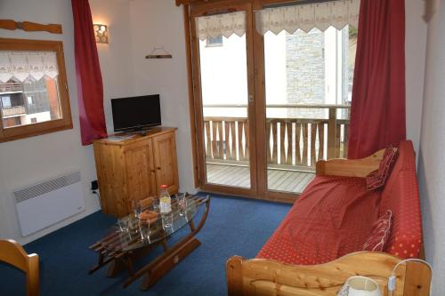 a living room with a bed and a balcony at l'Antre du Cerf in Villarodin-Bourget