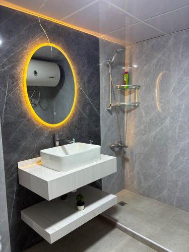 ein Badezimmer mit einem weißen Waschbecken und einem Spiegel in der Unterkunft Bright Rooms in Dubai