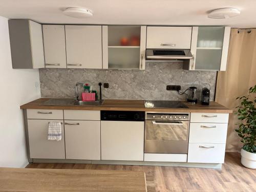 a kitchen with white cabinets and a sink at Ferienwohnung Korbach in Korbach