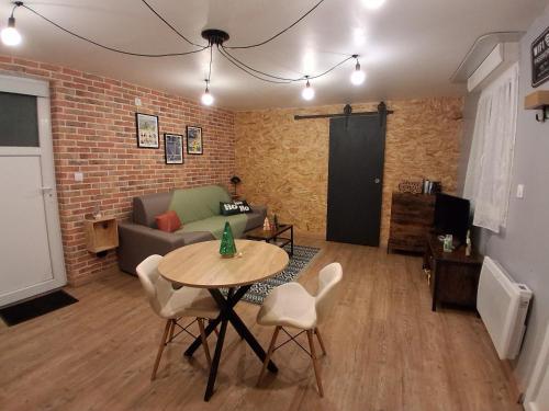a living room with a table and a couch at Le Stud'Eure in Saint-André-de-lʼEure
