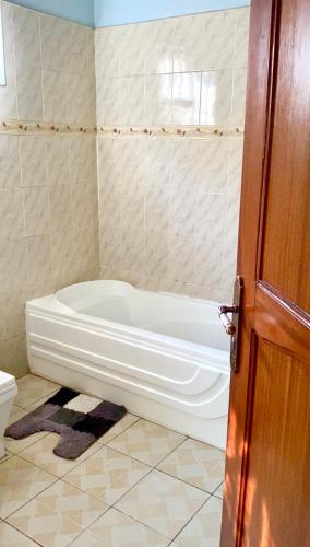 a bathroom with a bath tub in a room at Paradise Pathways Lweza in Kampala