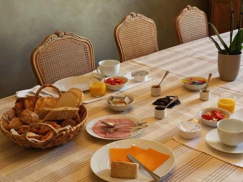 a table with a breakfast of bread and orange juice at La Sauternaise, luxury Boutique B&B in Sauternes