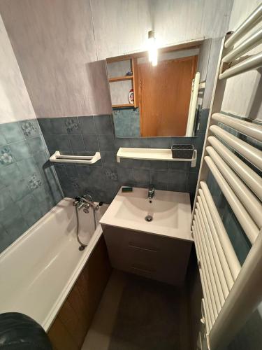 a small bathroom with a sink and a bath tub at Appartement 5 pers - Draps et serviettes inclus in La Lechere