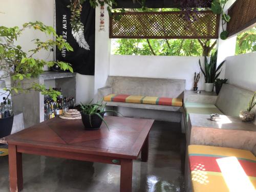 a living room with a table and a bench at Everdew Kandy Rooms in Kandy
