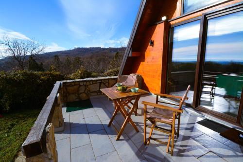 una casa con patio con mesa y 2 sillas en Kosmaj Escape, en Koraćica
