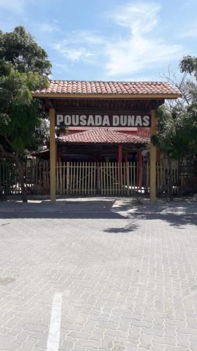 a sign for a pucada dunas restaurant at Pousada dunas in Barroquinha