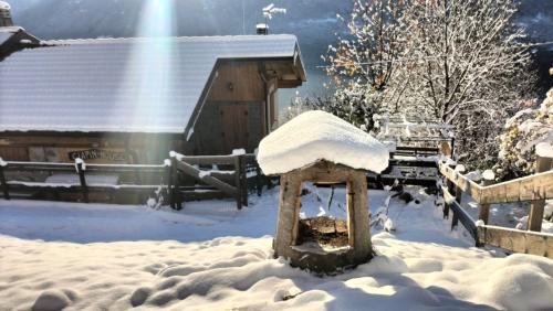 Een met sneeuw bedekt vogelhuisje voor een schuur. bij Ciapin House in Buglio in Monte