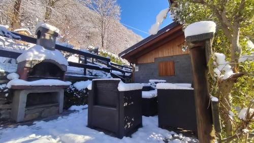 een hut in de sneeuw met een open haard bij Ciapin House in Buglio in Monte