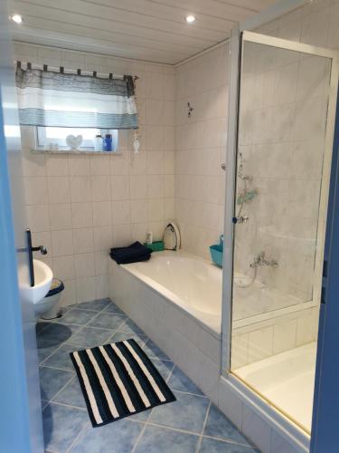 a bathroom with a tub and a shower and a toilet at Mente Azul in Pullenreuth