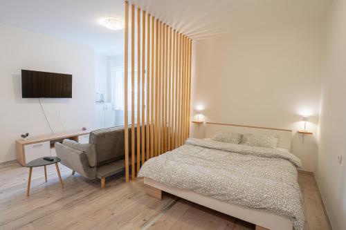 a bedroom with a bed and a chair at Studio apartman LuG in Ravna Gora