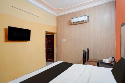 a hotel room with a bed and a flat screen tv at Hotel O Durgapuri Metro Station Lucknow Formerly Pal Awadh in Bādshāhnagar