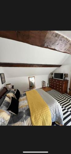 a bedroom with a bed with a yellow blanket at The Old Hanging Gate Inn in Madeley