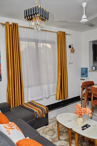 a living room with yellow curtains and a couch at Darflings Haven-Diani in Ukunda