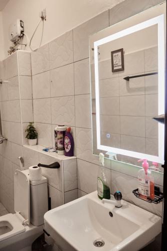 a white bathroom with a sink and a mirror at Darflings Haven-Diani in Ukunda