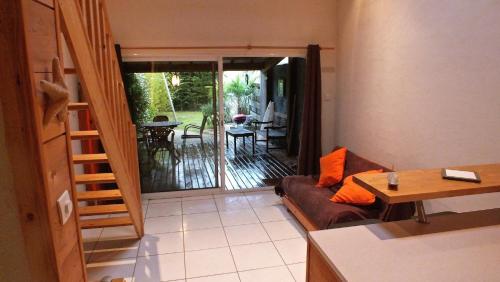 a living room with a couch and a sliding glass door at Aux portes de l ocean in Labenne