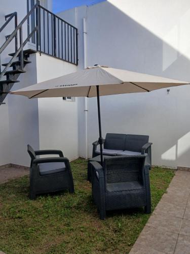 ネコチェアにあるNecochea-Casa para hasta 4 personas!の草の中の椅子2脚と傘
