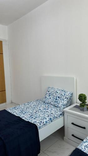 沙迦Bed space in Luxury hostel - سرير مفردفي شقة فندقية的一间小卧室,配有床和床头柜