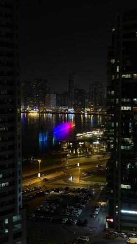 a city at night with cars parked in a parking lot at Bed space in Luxury hostel - سرير مفردفي شقة فندقية in Sharjah