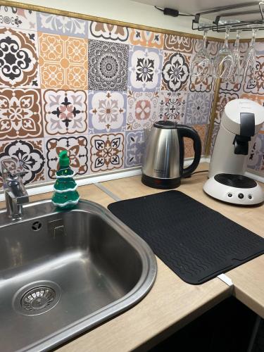 a kitchen counter with a sink and a coffee maker at La Suite Nocturne Climatisée avec écran Cinéma in Fère-en-Tardenois