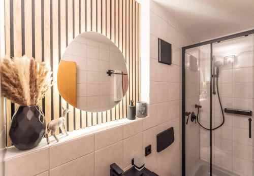 a bathroom with a mirror and a vase on a shelf at Bienenhaus #Bergblick im Sonnenhof in Seeg