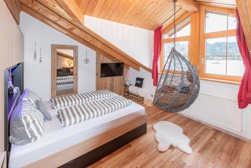 a bedroom with a bed and a hanging hammock at Bienenhaus #Bergblick im Sonnenhof in Seeg