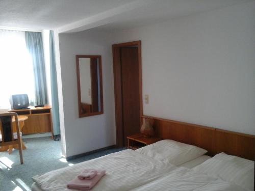 um quarto de hotel com uma cama com uma toalha rosa em Landhotel Zur Krone em Kieselbach