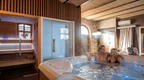 Borgo Degli Angeli Resort e Spa في San Vitale: شخصين في حوض استحمام في الحمام