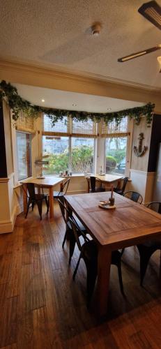 a dining room with tables and chairs and windows at Black Sheep Lodge in Holyhead