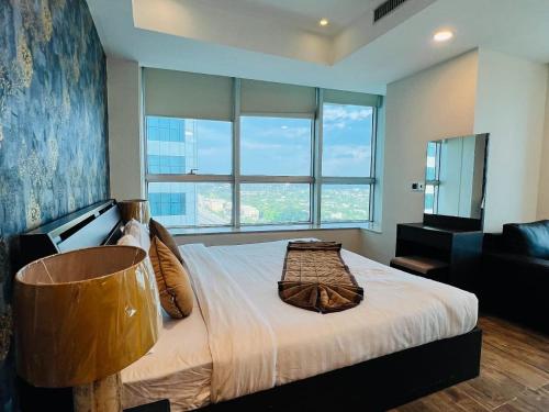 a bedroom with a large bed with a large window at The Panoramic Centauras in Islamabad