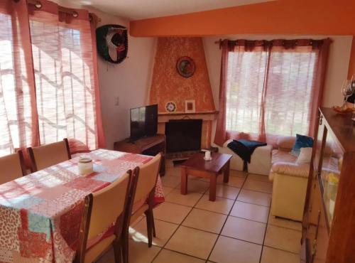 ein Wohnzimmer mit Tisch und Kamin in der Unterkunft Casa en Cuchilla Alta Biarritz in Cuchilla Alta