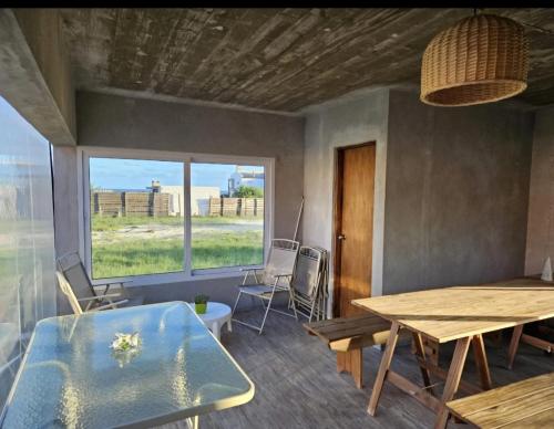 ein Esszimmer mit Tisch und Stühlen und einem Fenster in der Unterkunft Casa en Cuchilla Alta Biarritz in Cuchilla Alta