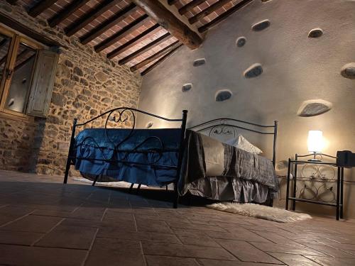 een bed in een kamer met een stenen muur bij Villa Terria in Casabasciana